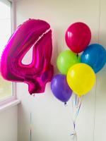 Ярко розовая цифра четыре и фонтан из шаров